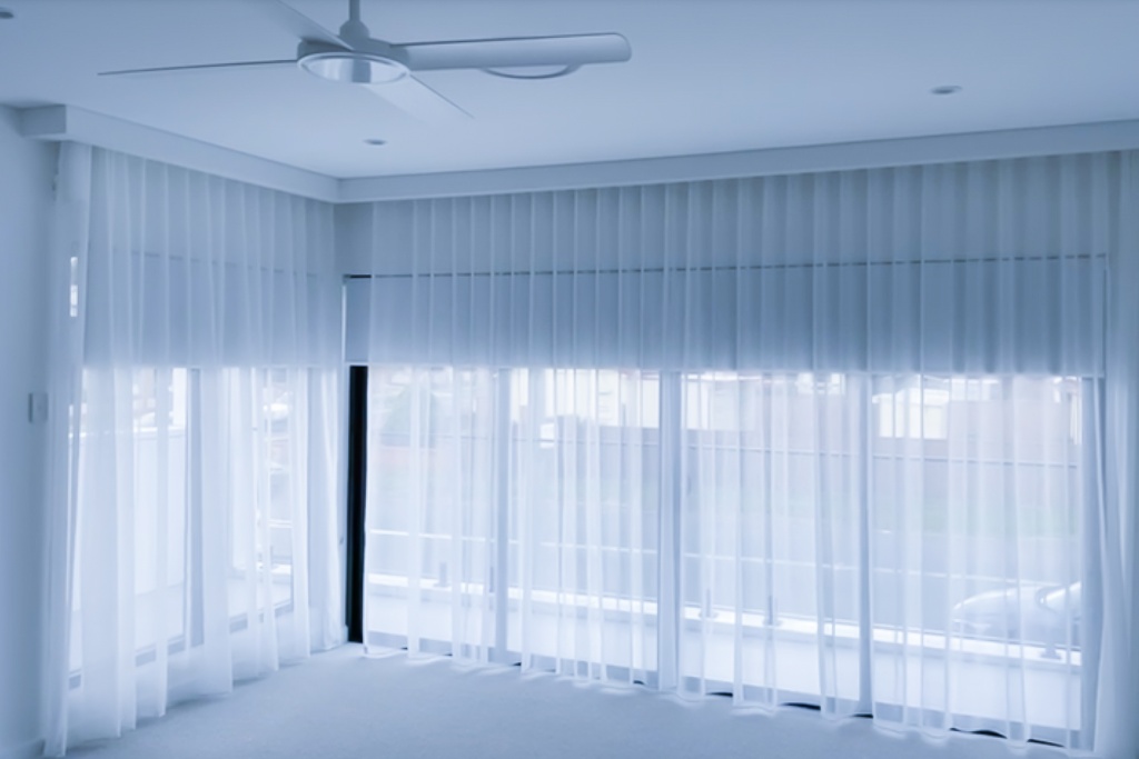 A subset of Unique Blinds' motorised sheer curtains is being depicted in a Sydney home to tie together a families minimalistic living room design.