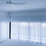 A subset of Unique Blinds' motorised sheer curtains is being depicted in a Sydney home to tie together a families minimalistic living room design.